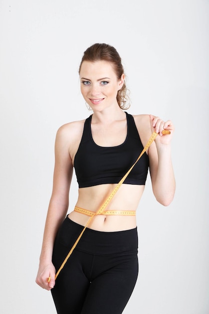 Beautiful young woman with measuring tape