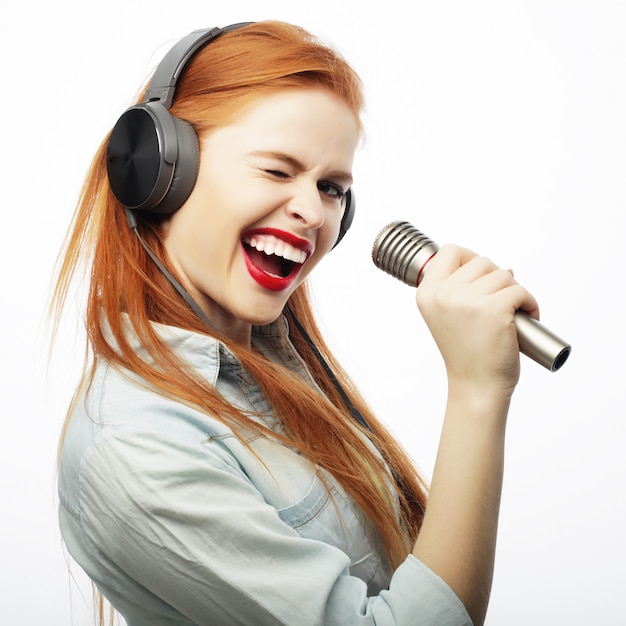 Beautiful young woman with microphone and headphones