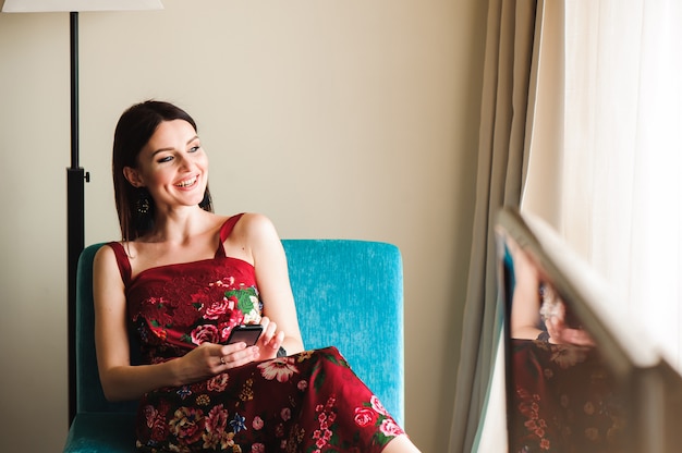 Beautiful young woman with mobile phone at home.