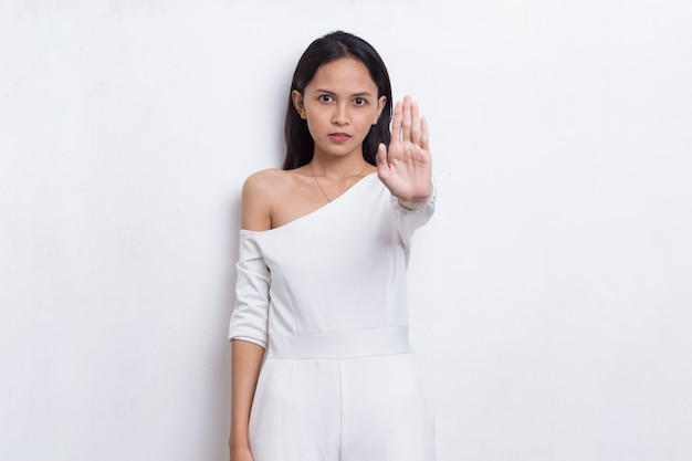 Beautiful young woman with open hand doing stop sign with serious expression defense gesture