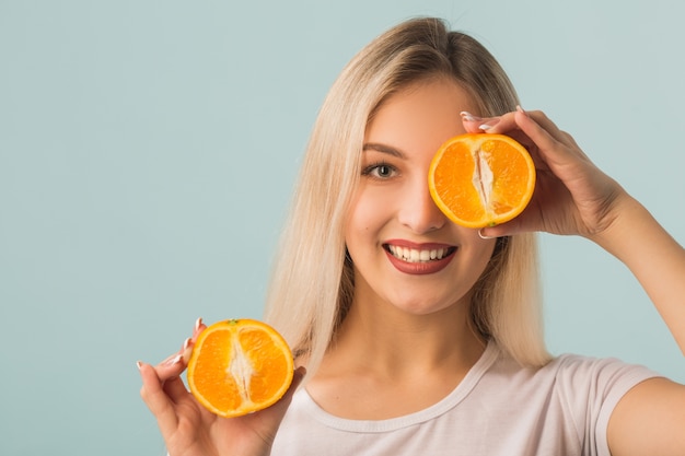 Foto bella giovane donna con l'arancio nelle mani