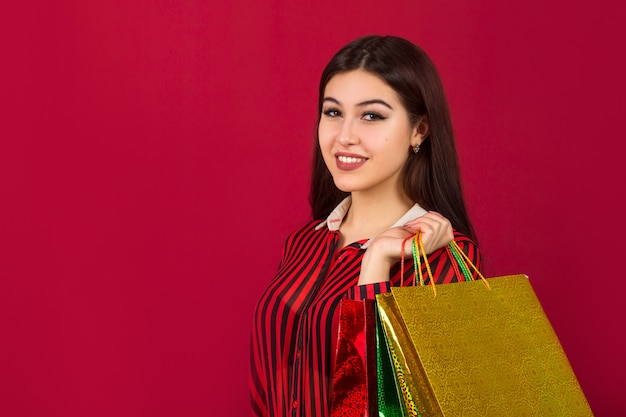 Beautiful young woman with packages in hands 