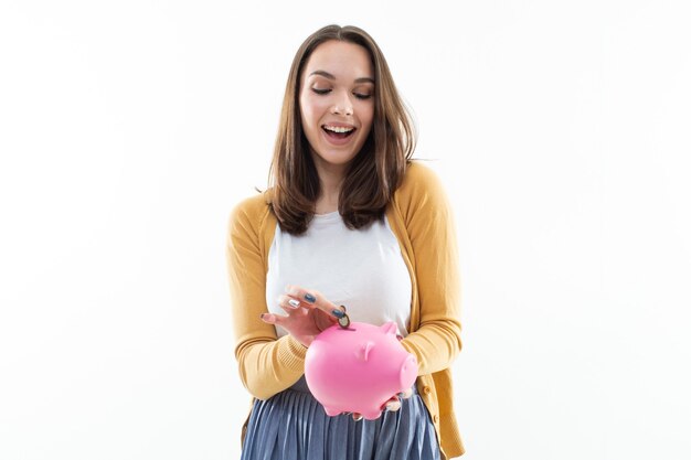 Beautiful young woman with a piggy bank