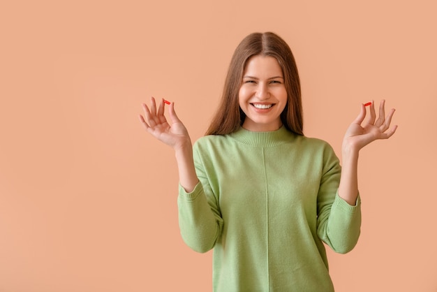 Beautiful young woman with pills on color surface