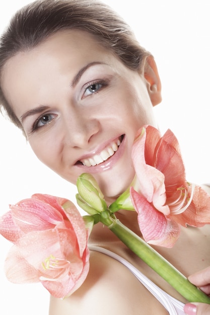 Beautiful young  woman with pink flower over white 