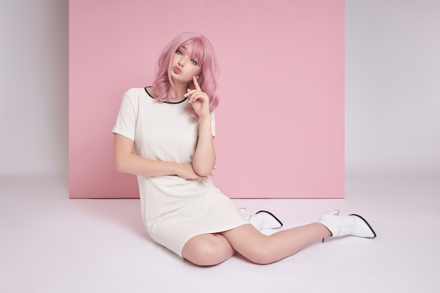 Beautiful young woman with pink hair wearing a dress