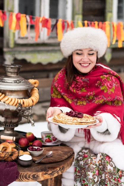 팬케이크와 samovar.Shrovetide 개념 Maslenitsa 접시와 함께 아름 다운 젊은 여자. 수직의