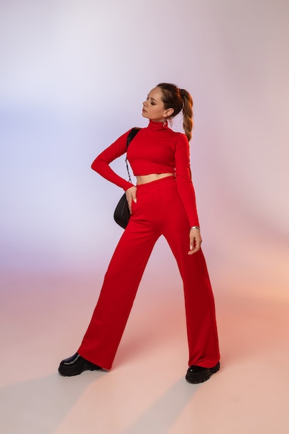 Beautiful young woman with pretty face posing in fashionable red outfit