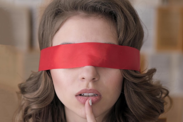 Beautiful young woman with a red blindfold