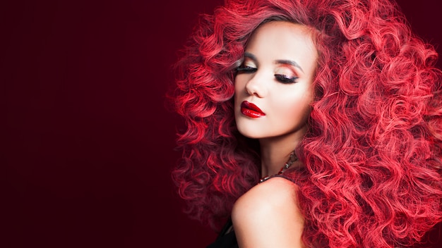 Красивая молодая женщина с рыжими волосами. Яркий макияж и прическа