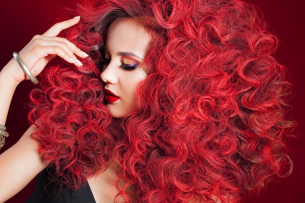Красивая молодая женщина с рыжими волосами. Яркий макияж и прическа