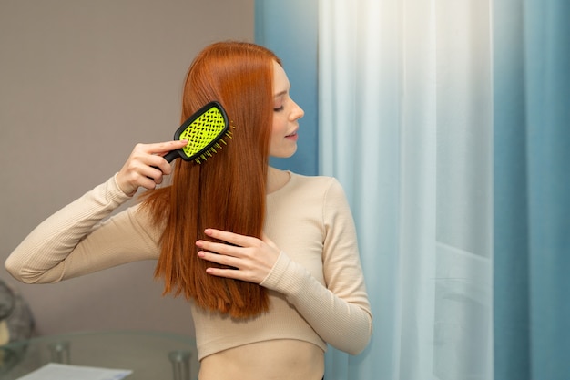 beautiful young woman with red hair with comb