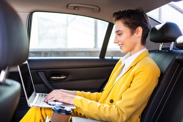 Beautiful young woman with short hair drives car in the city