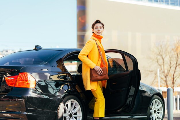 Beautiful young woman with short hair drives car in the city