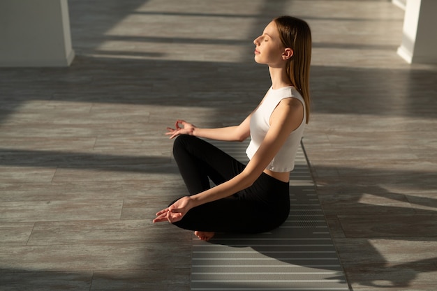 beautiful young woman with a slim figure is engaged in yoga in the hall