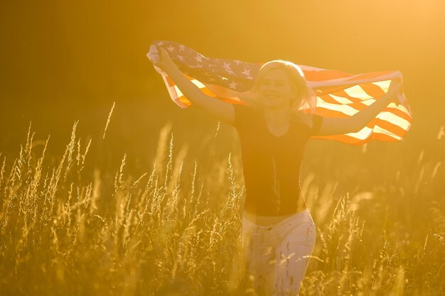 アメリカの国旗を持つ美しい若い女性