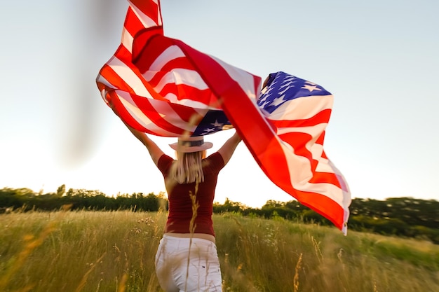 アメリカの国旗を持つ美しい若い女性