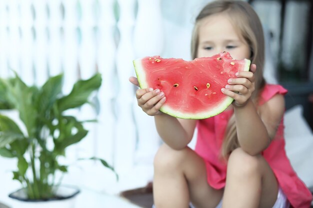 Beautiful young woman with watermelon in park on sunny day