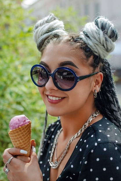 Photo beautiful young woman with white dreadlocks eating ice cream