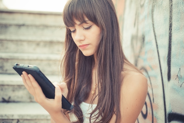 beautiful young woman with white dress using tablet 