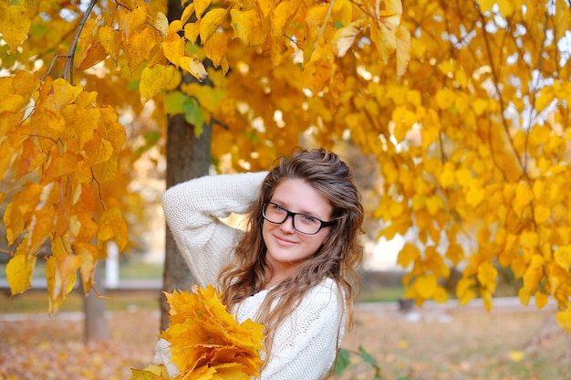 Beautiful young woman with yellow autumn wreath 