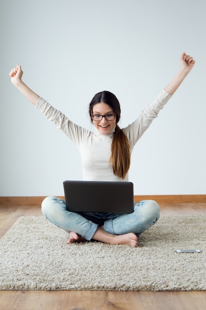 Beautiful young woman working on her laptop at home.