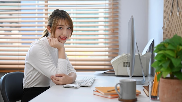 Bella giovane donna che lavora online a casa con dispositivi moderni