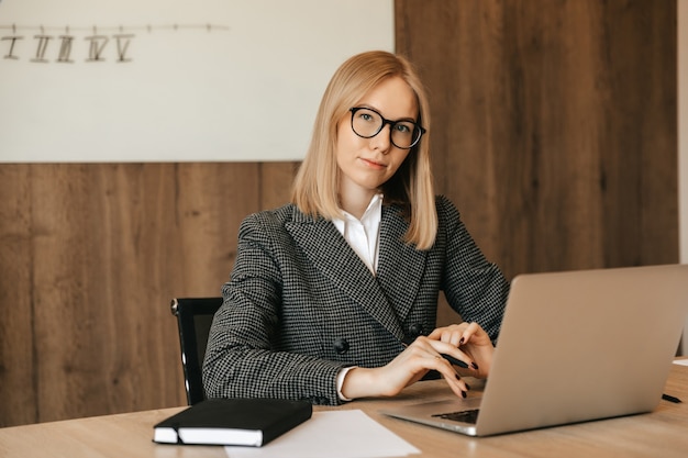 Beautiful young woman working using laptop computer, concentrated and serious, good responsible office worker.