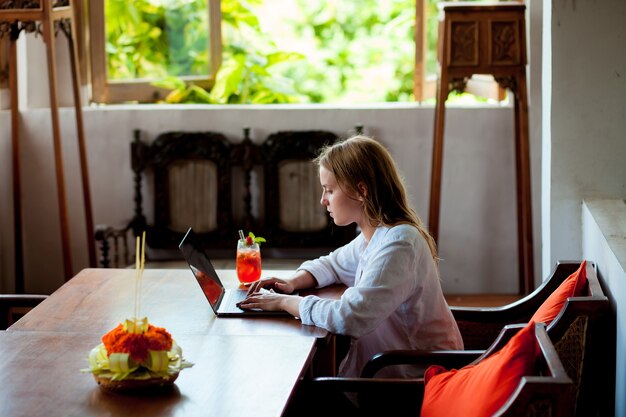 A beautiful young woman works on her laptop