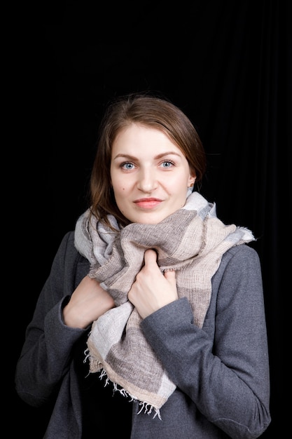 Bella giovane donna ha avvolto il collo in una calda sciarpa di lana