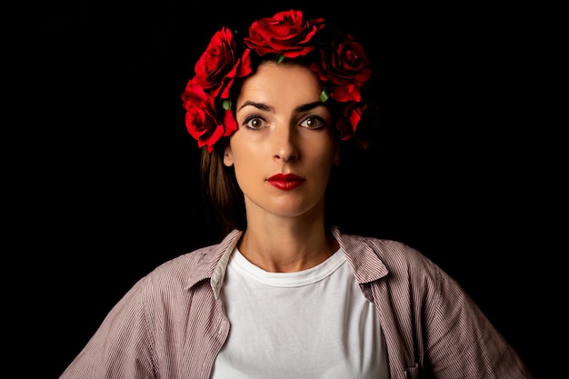 Beautiful young woman in a wreath of red flowers