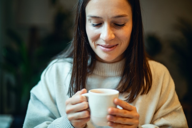 Beautiful young woman writing her business plans on diary