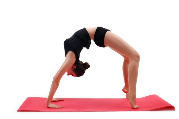 Beautiful young woman yoga posing on a studio background