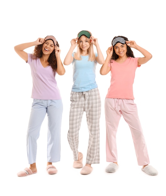 Photo beautiful young women in pajamas and with sleep masks on white