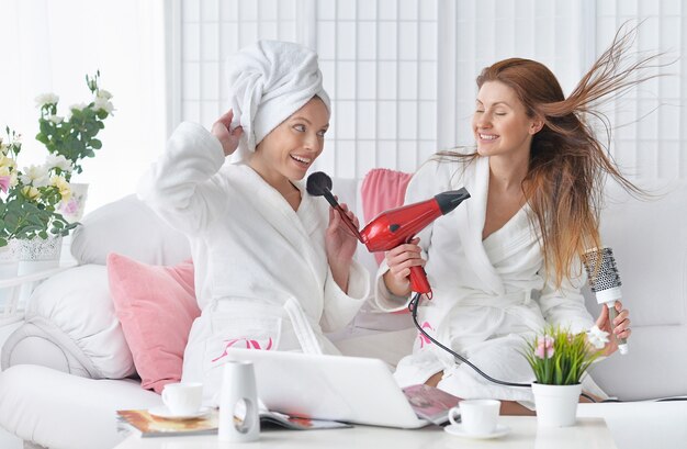 Beautiful young women wearing a white bathrobes with laptop