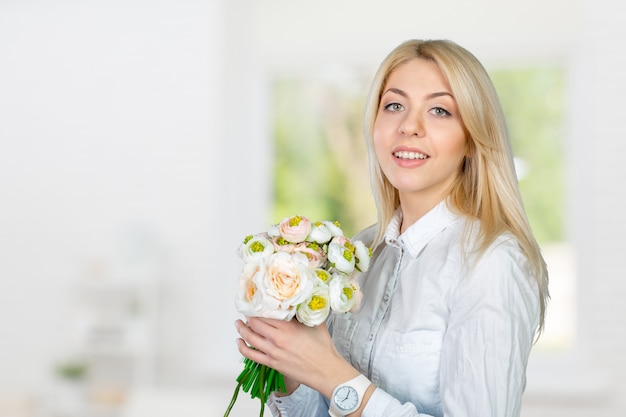 花を持つ美しい若い女性