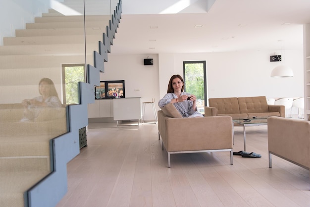 Beautifull young woman in a bathrobe enjoying morning coffee in her luxurious home villa