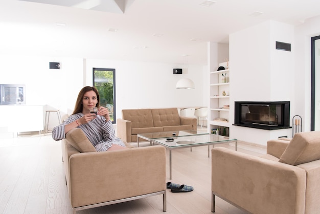 Beautifull young woman in a bathrobe enjoying morning coffee in her luxurious home villa