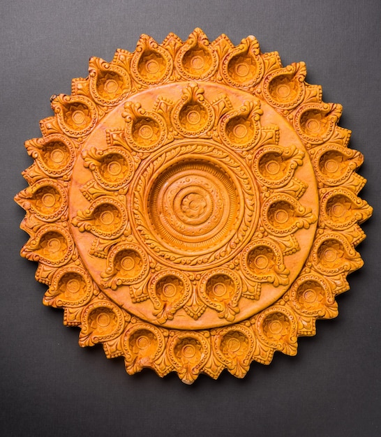 Photo beautifully carved designer diwali diya plate made up of terracotta, isolated and selective focus