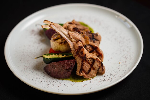 Photo beautifully decorated baked ribs on a white plate