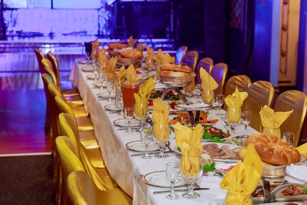 さまざまなフードスナックと前菜、サンドイッチ、キャビア、企業のパーティーイベントや結婚披露宴での新鮮な果物を備えた美しく装飾されたケータリングバンケットテーブル