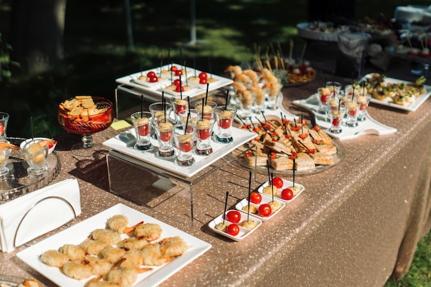 Beautifully decorated catering banquet table with different food snacks and appetizers with sandwich