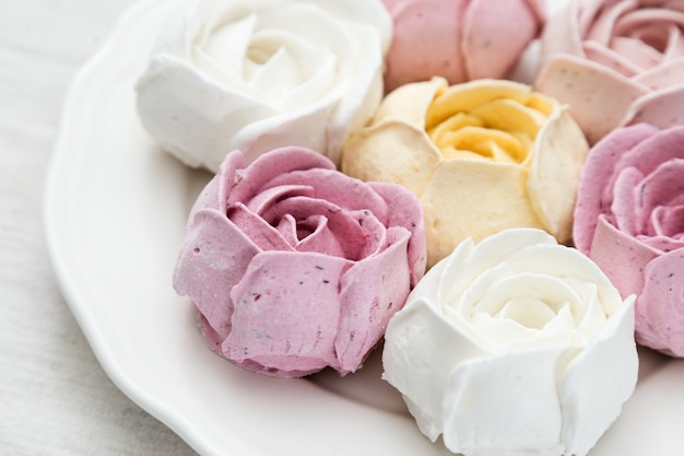 Beautifully decorated dessert. Colorful flowers from marshmallow. Sweet edible tulips and roses. Close up, selective focus.