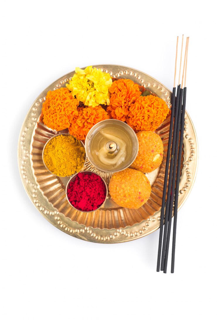 Beautifully Decorated Pooja Thali for festival celebration to worship, haldi or turmeric powder and kumkum, flowers, scented sticks in brass plate, hindu puja thali