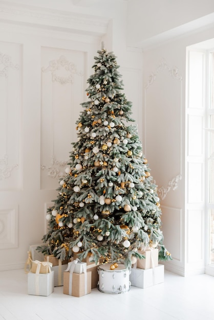 A beautifully decorated room with a Christmas tree with gifts underneath Interior Christmas magic luminous tree new year Soft selective focus