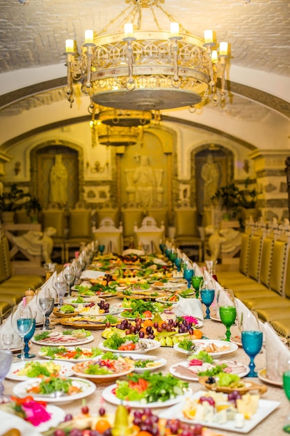 Beautifully served table for banquet in restaurant White napkins and blue and green wine glasses