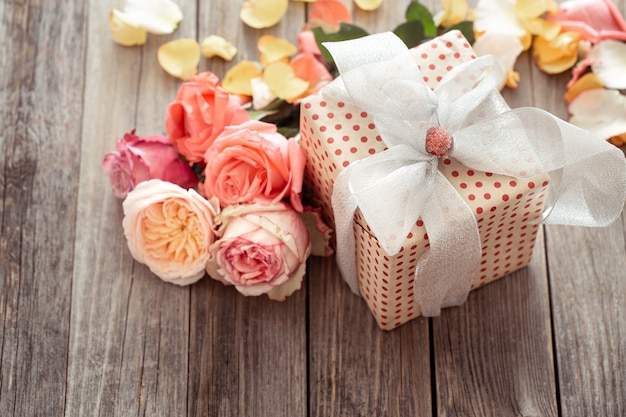 Beautifully wrapped gift box and fresh roses. Holiday concept.