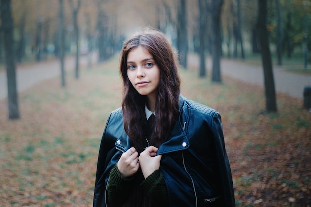 Beautuful Girl with long hair in autumn park. Close-up girl portrait