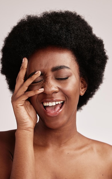 beauty black woman and smile of a female person face with hands happy about facial wellness cosmetics and model in a isolated studio with skincare doing dermatology detox and spa self care