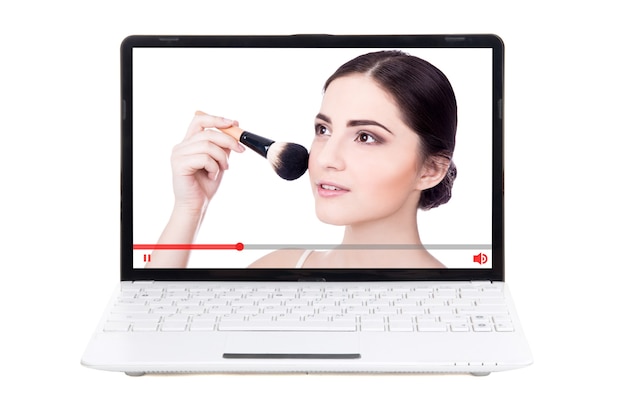 Beauty blog concept - mooie vrouw die laat zien hoe je make-up op het laptopscherm aanbrengt